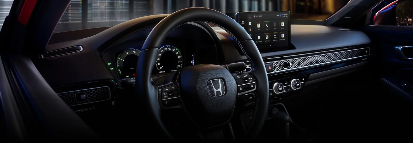 The Civic cockpit with steering wheel, driver display and centre touchscreen.