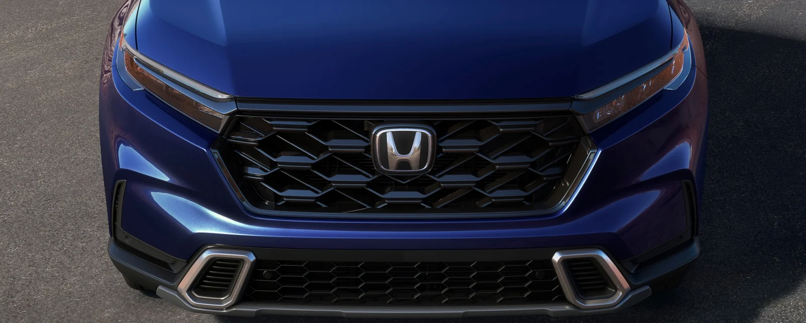 Close-up of the honeycomb grille and Honda badge on a blue CR-V.