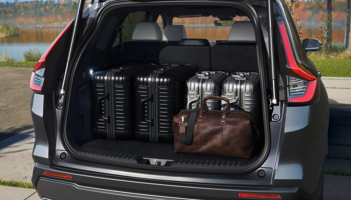 The open cargo area of a CR-V loaded with suitcases and a leather duffel bag.