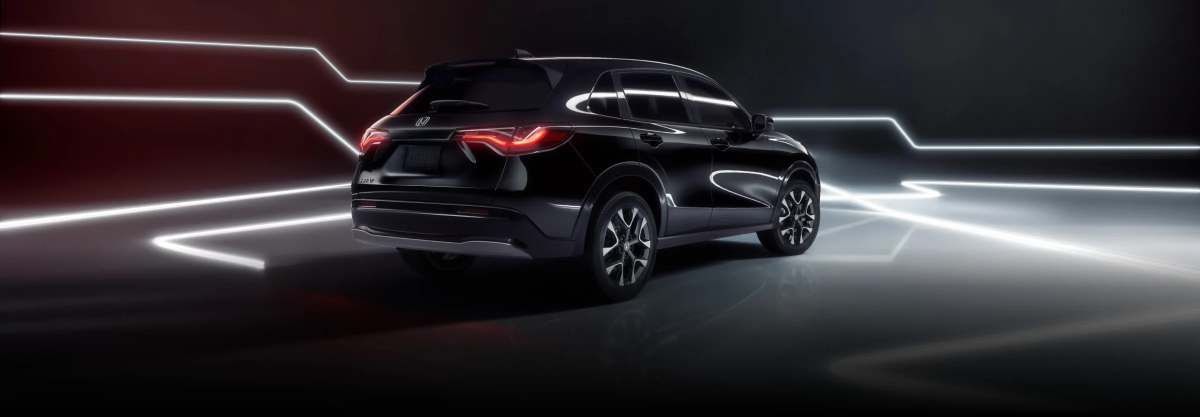 Rear three-quarter view of a black Honda HR-V surrounded by streaks of light.