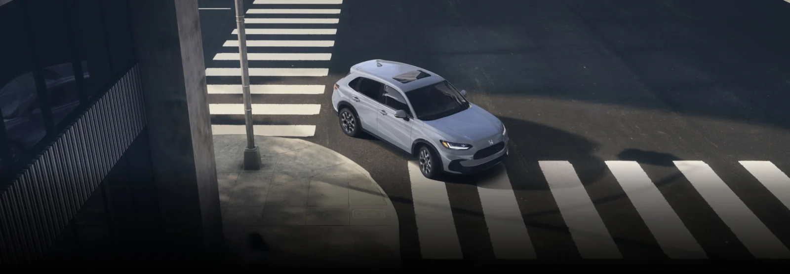 A white HR-V turning through a city crosswalk, seen from above.