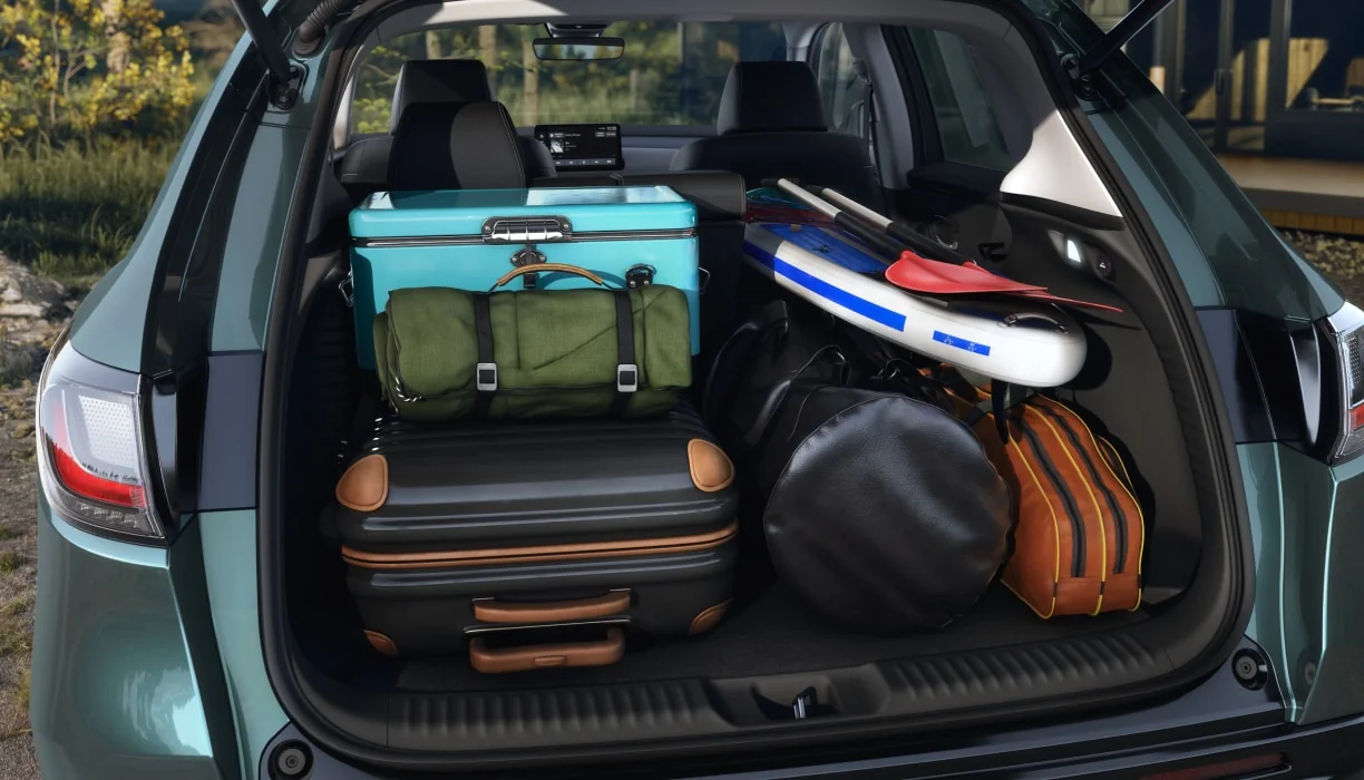 The open cargo area of an HR-V packed with luggage, bags and a paddleboard.